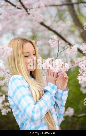 Giovane donna bionda in un parco in primavera Foto Stock