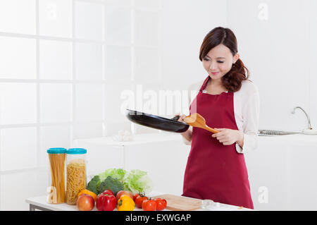 Giovane donna tenendo un pan e la siviera con sorriso, Foto Stock