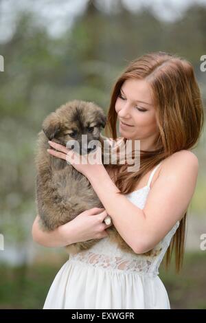 Giovane donna con un misto di razza cucciolo di cane in giardino Foto Stock