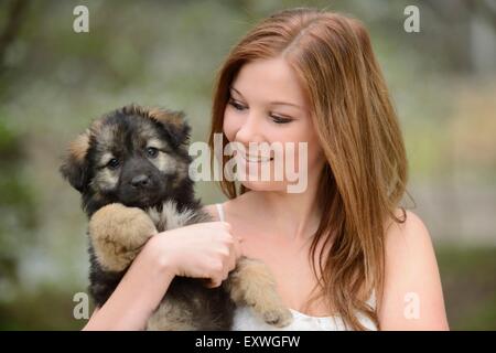 Giovane donna con un misto di razza cucciolo di cane in giardino Foto Stock