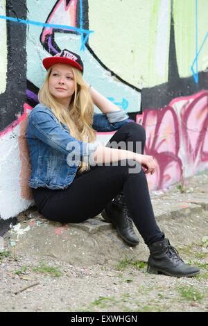 Giovane donna in corrispondenza di un muro di graffiti, Norimberga, Baviera, Germania, Europa Foto Stock