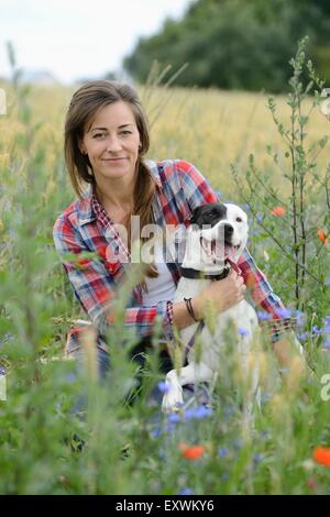 Donna con un cane mongrel su un prato, Baviera, Germania, Europa Foto Stock