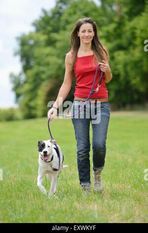 Donna con un cane mongrel su un prato, Baviera, Germania, Europa Foto Stock