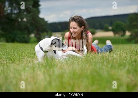 Donna con un cane mongrel su un prato, Baviera, Germania, Europa Foto Stock