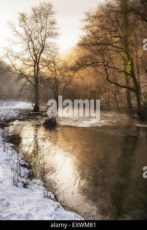 Bella neve invernale coperto paesaggio di campagna del fiume che scorre con riflessioni Foto Stock