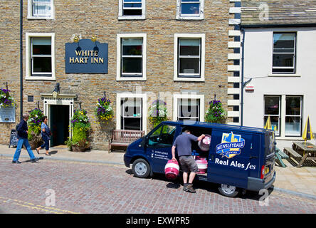 L'uomo offrendo la birra per il White Hart Inn Hawes, Wensleydale, Yorkshire Dales National Park, North Yorkshire, Inghilterra, Regno Unito Foto Stock