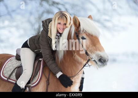 Giovane donna cavalcare cavalli di razza Haflinger Foto Stock