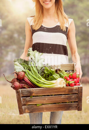 Donna che trasportano le verdure fresche nella casella Foto Stock