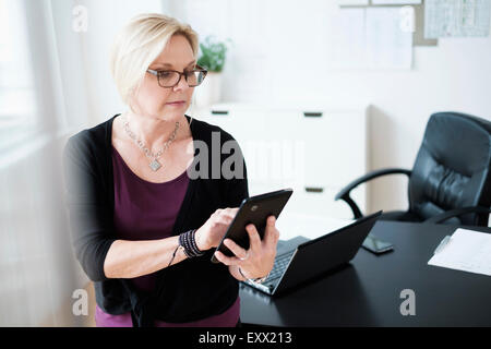 Imprenditrice utilizzando tablet in ufficio Foto Stock