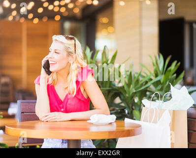 Donna che parla al telefono in cafe Foto Stock