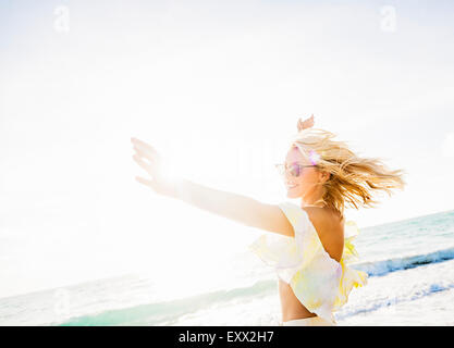 Giovane donna sorridente sulla spiaggia Foto Stock