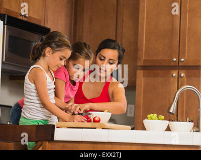 Madre e bambini (6-7, 8-9) preparare il cibo in cucina Foto Stock