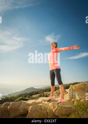 Donna in abbigliamento sportivo con le braccia tese Foto Stock