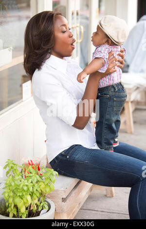 Ritratto di donna sorridente holding figlio (12-17 mesi) Foto Stock