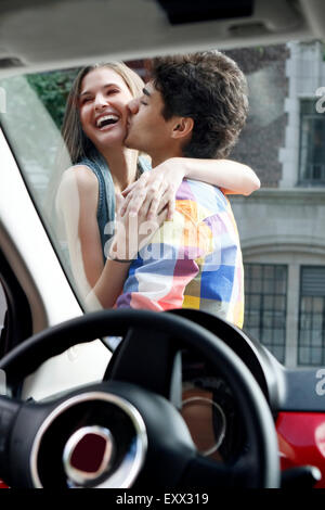 Giovane kissing al di fuori della vettura Foto Stock