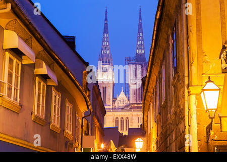 Strada illuminata e le guglie della cattedrale di Zagabria Foto Stock