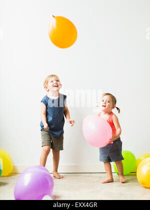Bambini (2-3) giocando con palloncini Foto Stock