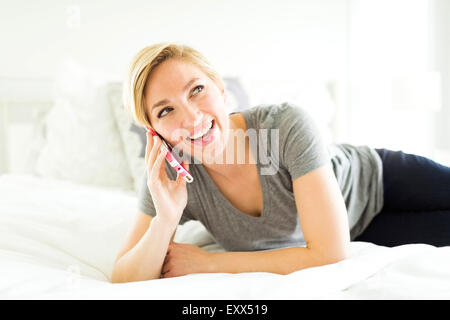 Metà donna adulta parlando al telefono in camera da letto Foto Stock