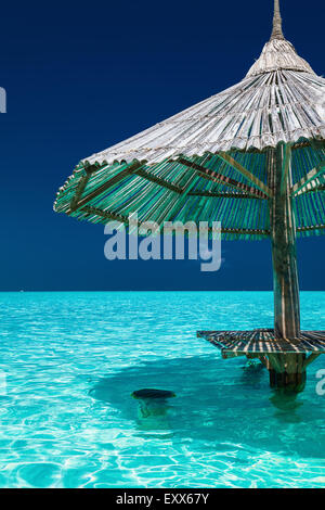 Il bambù ombrellone con posti al bar in acqua di isola tropicale Foto Stock