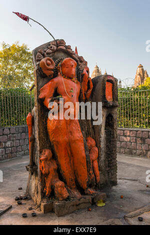 Dio indù soffocato in pasta di colore arancione al di fuori di un moderno tempio di Khajuraho, Madhya Pradesh, India Foto Stock