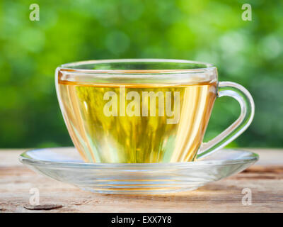 Tazza da tè sul tavolo di legno. Sfondo verde. Foto Stock