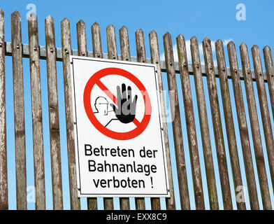 Sicurezza tedesco segno incarica il pubblico per tenere fuori la stazione al di là della staccionata - Betreten der Bahnanlage verboten! Foto Stock