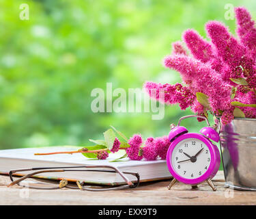 Vintage vita ancora: fiori nel secchio, rosa sveglia e il cucchiaio sul tavolo in legno all'esterno Foto Stock