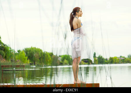 Donna in piedi alla fine del lago di pier godendo di view Foto Stock