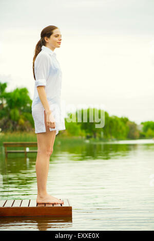 Donna in piedi alla fine del lago di dock guardando a vista Foto Stock