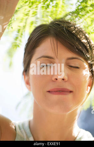 Donna con gli occhi chiusi all'aperto, ritratto Foto Stock