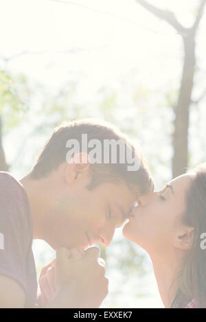 Coppia insieme all'aperto, donna baciando l uomo di fronte Foto Stock