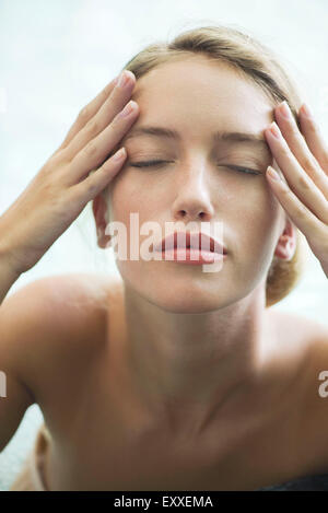 Donna rilassante in piscina con gli occhi chiusi Foto Stock