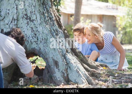 Famiglia giovane esplorare scavato tronco di albero Foto Stock