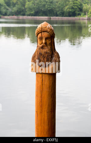 Statua in legno scultura di un uomo barbuto nel lago a Hartsholme parco vicino Lincoln Foto Stock