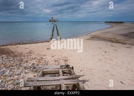 Bellissima vista sul Mar Baltico costa sabbiosa con vecchi edifici militari dalla II guerra mondiale e frangiflutti in legno. Foto Stock