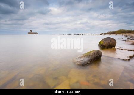 Bellissima vista sul Mar Baltico costa sabbiosa con vecchi edifici militari dalla II guerra mondiale e frangiflutti in legno. Foto Stock