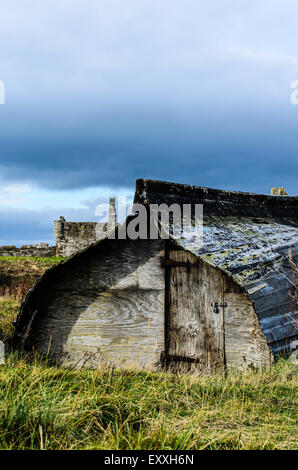 Capovolta vecchie barche usate un capannone o la memorizzazione su Lindisfarne. Foto Stock