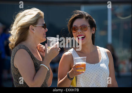 Due donna gustando un bicchiere di birra all'esterno. Foto Stock
