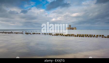 Bellissima vista sul Mar Baltico costa sabbiosa con vecchi edifici militari dalla II guerra mondiale e frangiflutti in legno. Una lunga esposizione foto Foto Stock