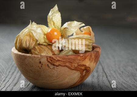 Physalis frutto nella tazza di olive su oak tavolo in legno Foto Stock