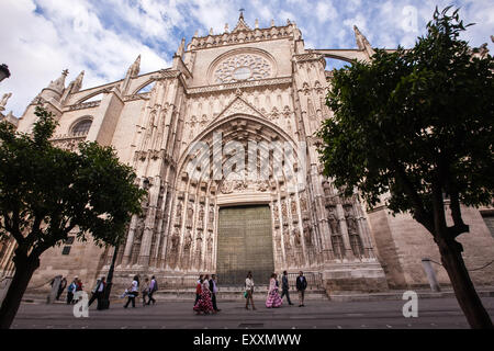 Cattedrale di Siviglia porta nel centro di Siviglia, in Andalusia, Spagna, Europa. La gente del posto indossando il tradizionale abito di Siviglia nel mese di aprile Foto Stock