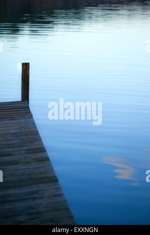 Pontile in legno su un lago al tramonto Foto Stock