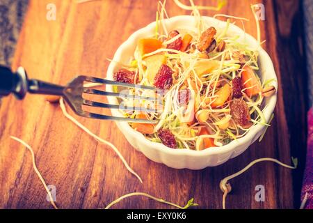 Foto d'epoca di lenticchie fresche e i germogli di grano con Insalata di carote, uva passa, olio d'oliva e aglio Foto Stock