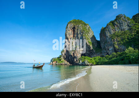 Unico longtail boat arrivando a scenic mattina paesaggio di Phranang spiaggia di Railay, Krabi, Thailandia Foto Stock