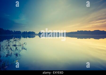 Vintage foto del tramonto sul lago tranquillo paesaggio con una vecchia foto di umore. Foto Stock