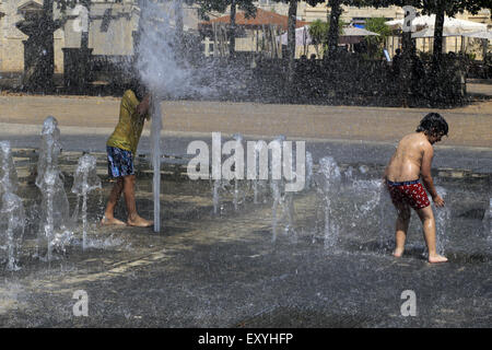 La città di Montpellier, Languedoc-Roussillon, Francia. 17 Luglio, 2015. Per alte temperature dovuta all'onda di calore si stabilirono in Francia i bambini sono dati un campo giorno giocando nella fontana di Zeus quartiere Antigone Montpelllier. Credito: Digitalman/Alamy Live News Foto Stock