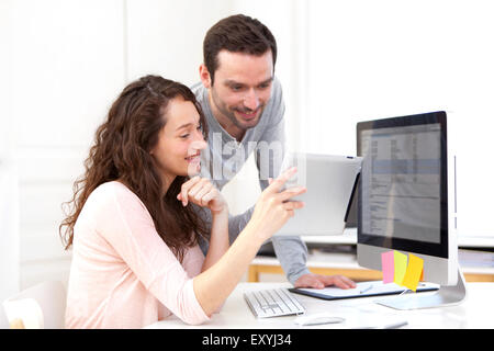 Vista della donna che lavorano su tablet con il suo collaboratore Foto Stock
