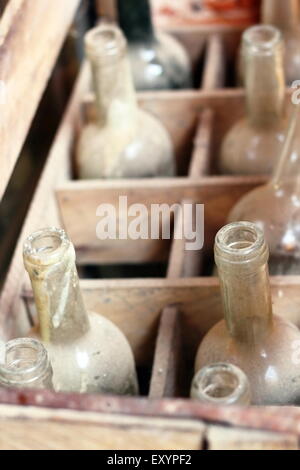 Vuoto vecchie bottiglie di vino in una scatola di legno Foto Stock