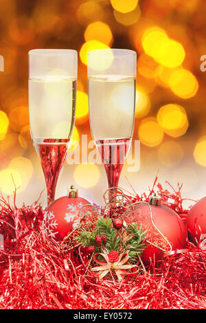 Natale ancora in vita - due bicchieri di champagne al rosso decorazioni di Natale con giallo e viola sfocate luci di Natale backgrou Foto Stock