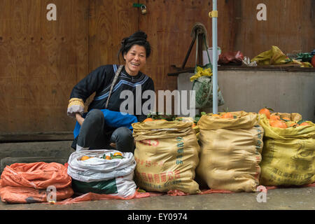 Dong donna vendita di arance, Rongjiang Mercato, Guizhou, Cina Foto Stock